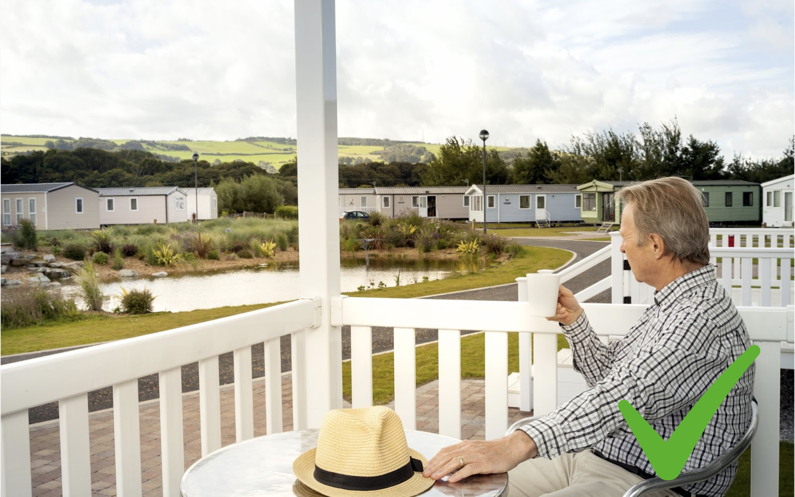 Man drinking coffee overlooking a caravan park